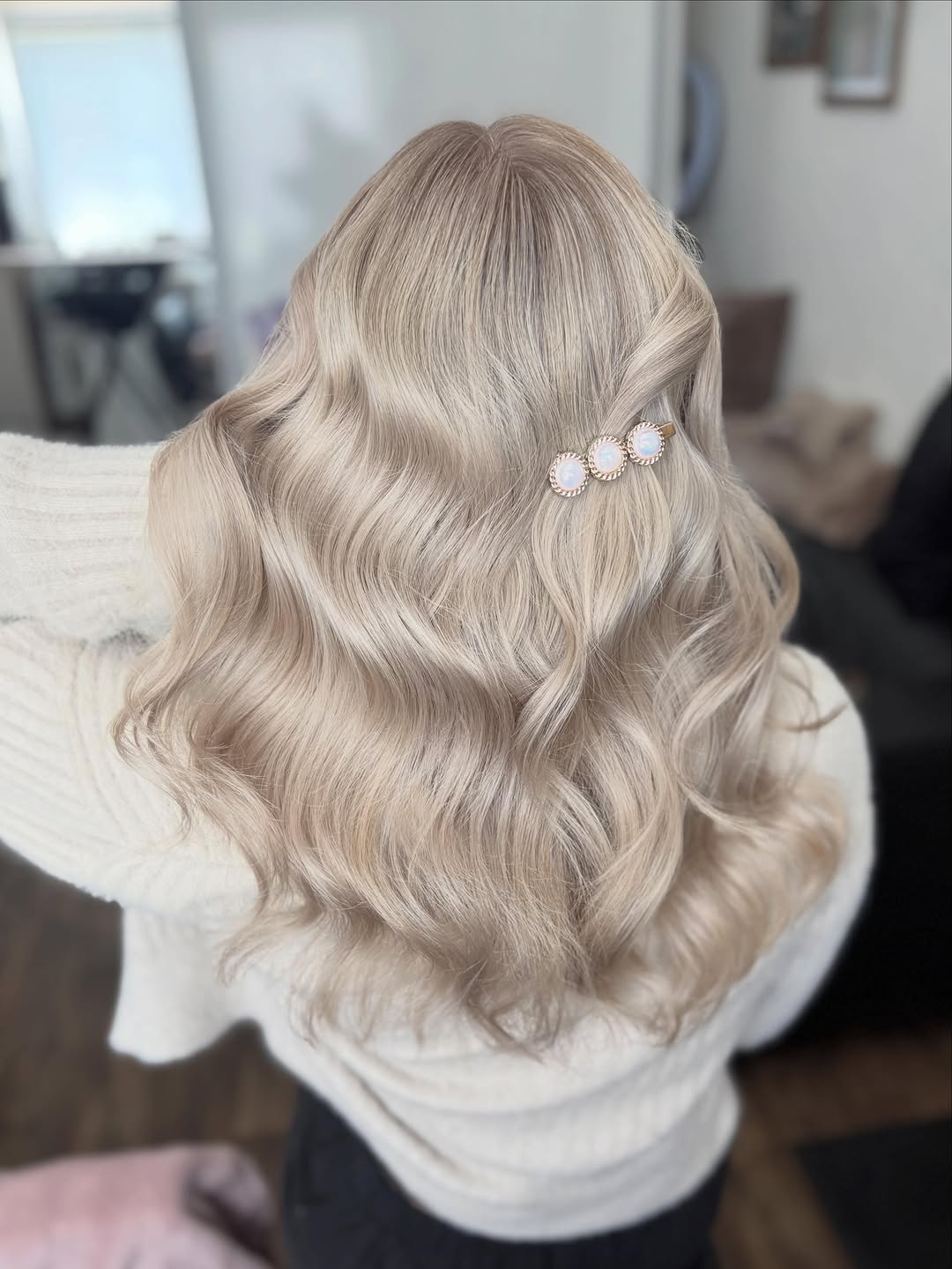 Detail zadní části hlavy klientky s vlnitými blond vlasy sepnutými ozdobnou sponou